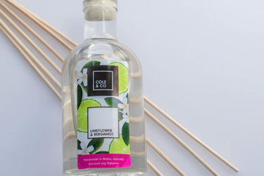 A bottle of Anna Davies Cole & Co Lime Flower & Bergamot Diffuser with sticks next to it.