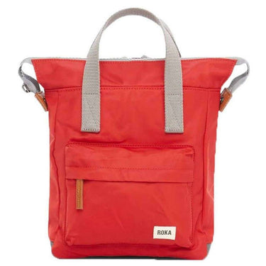 A red weather resistant Roka Bantry B Small Sustainable Nylon bag with a white label from Roka London Bags.