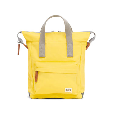 A yellow weather-resistant Roka Bantry B Small Sustainable Nylon Bag with a gray handle from Roka London Bags.